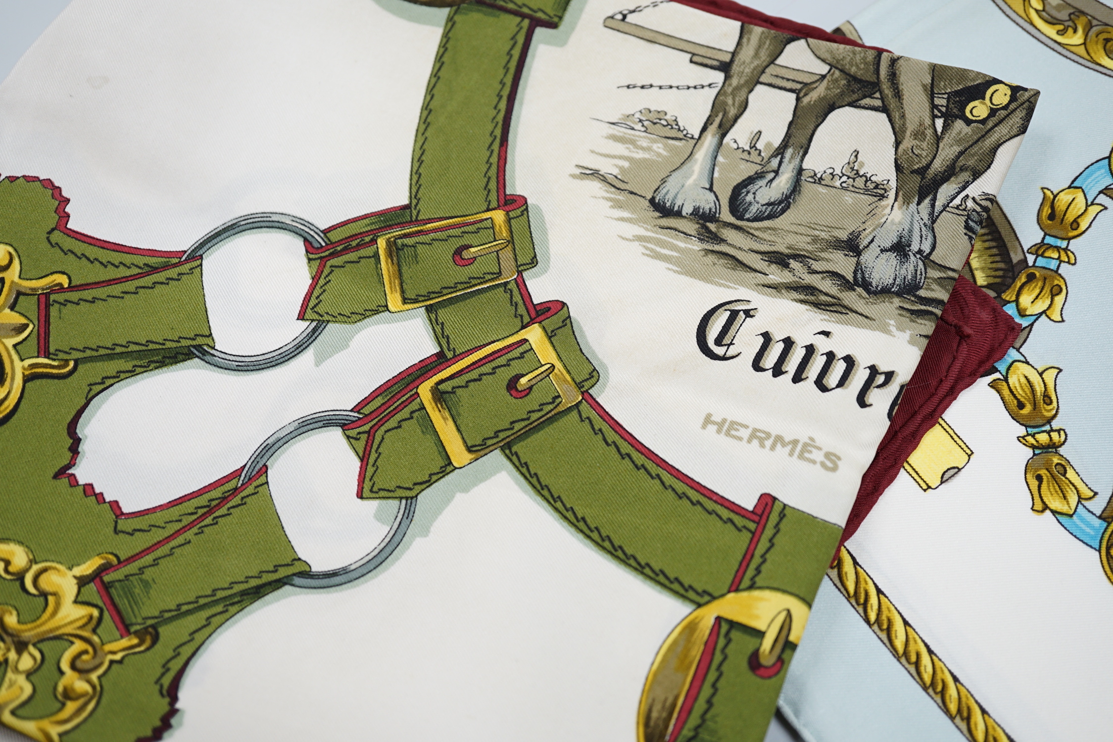 Four vintage Hermes silk scarves including two retailed by Harrods comprising Cuivreries, Roues de Canon, Napoleon and Puzzle